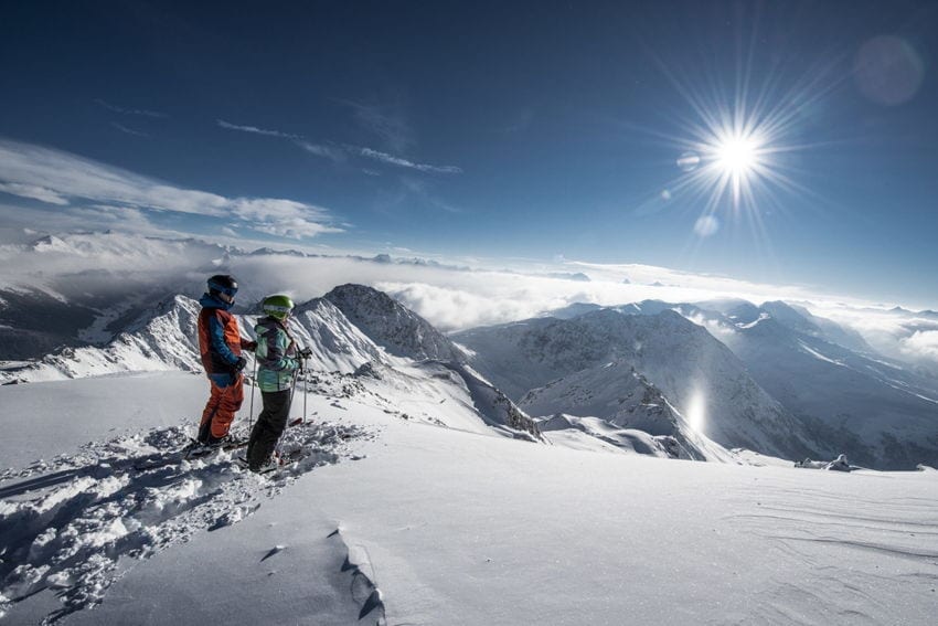 a ski guide showing the mountains to a woman