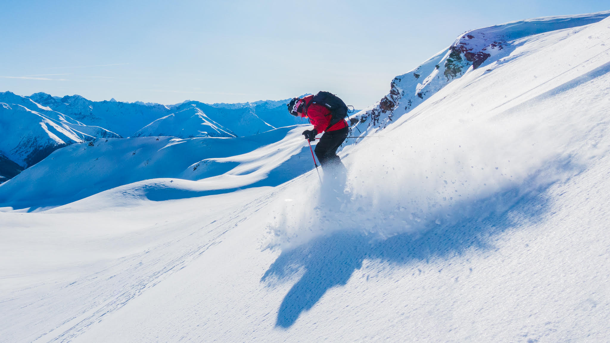 Man wearing red ski jacket skiing off piste in Davos