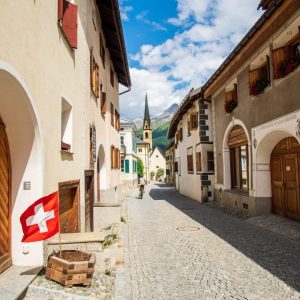 Frau die durch das Dorf S-Chanf fährt