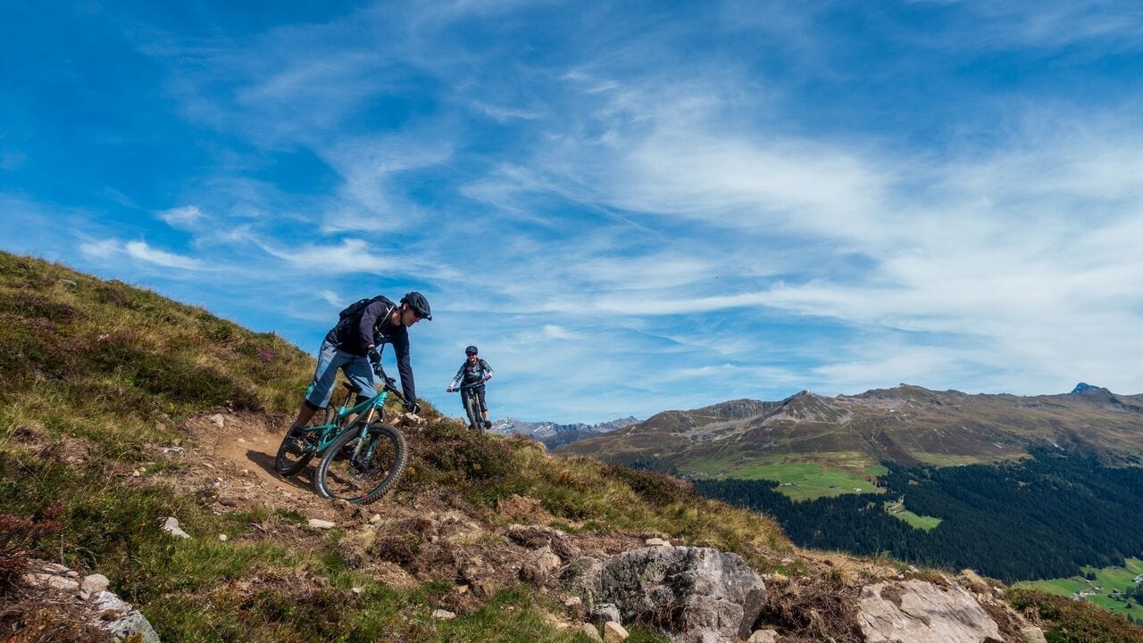 two mountain bikers downhill on the top of the mountain in Davos